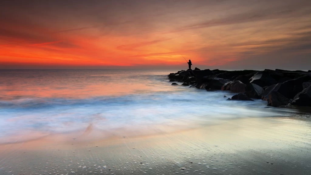 sunset ocean rocks waves sky clouds