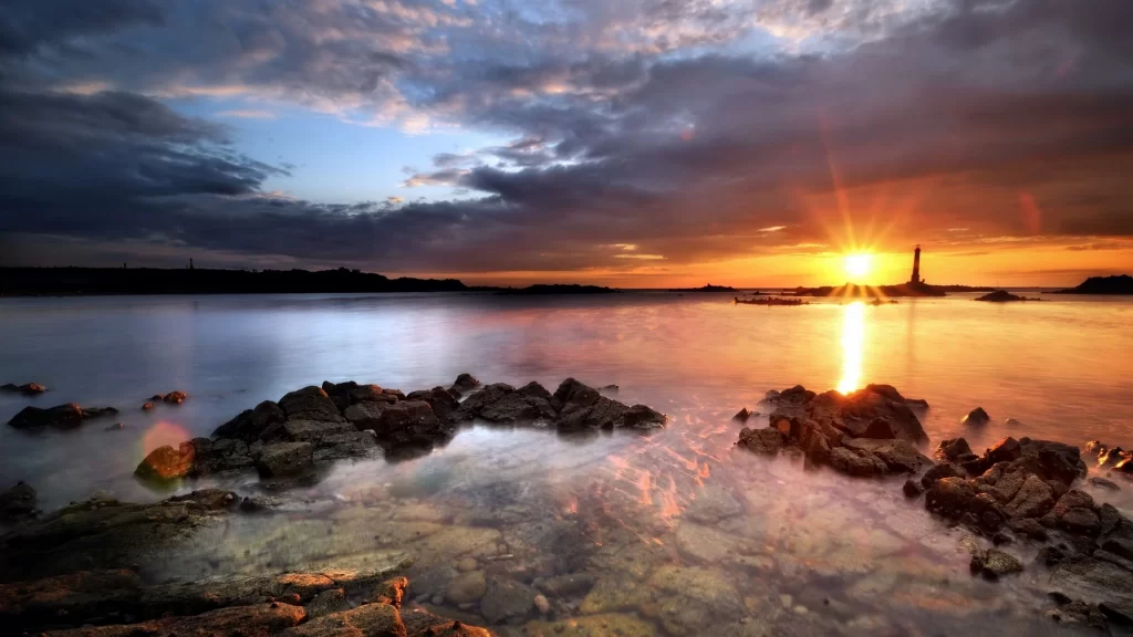 sunset water rocks sky clouds lighthouse