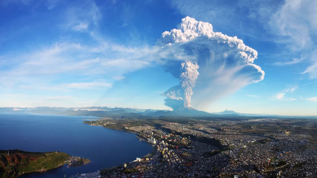 volcano eruption smoke cloud cityscape water body