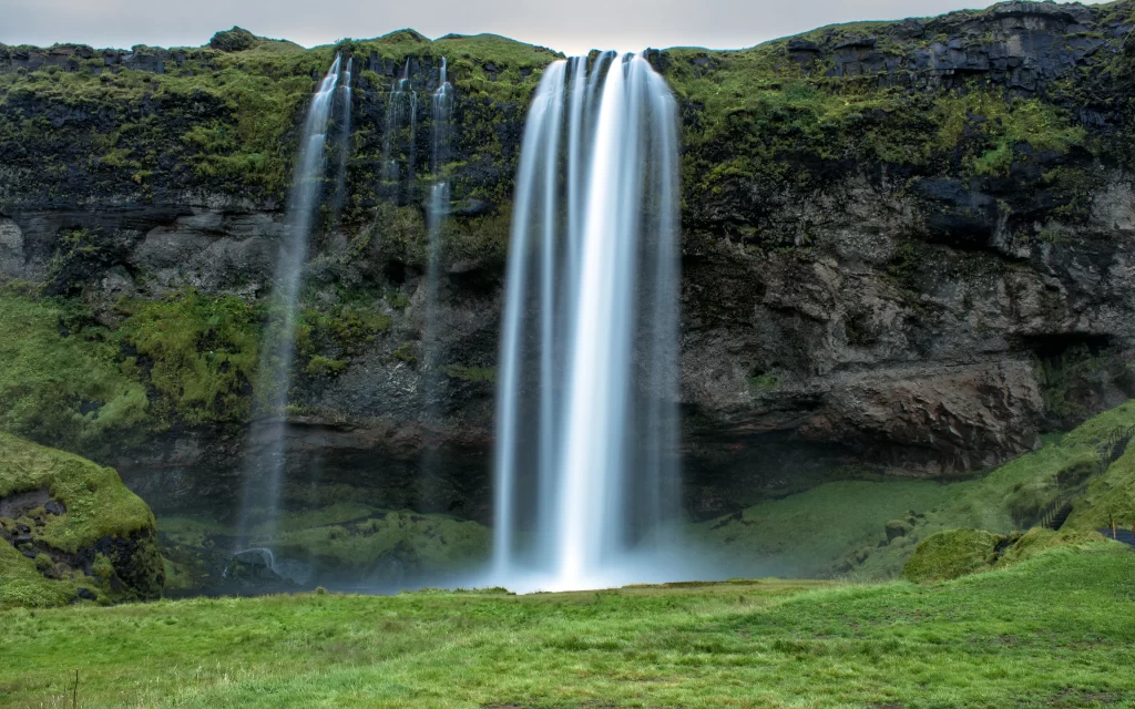 Waterfall Lush Greenery Rocky Cliff Misty Atmosphere