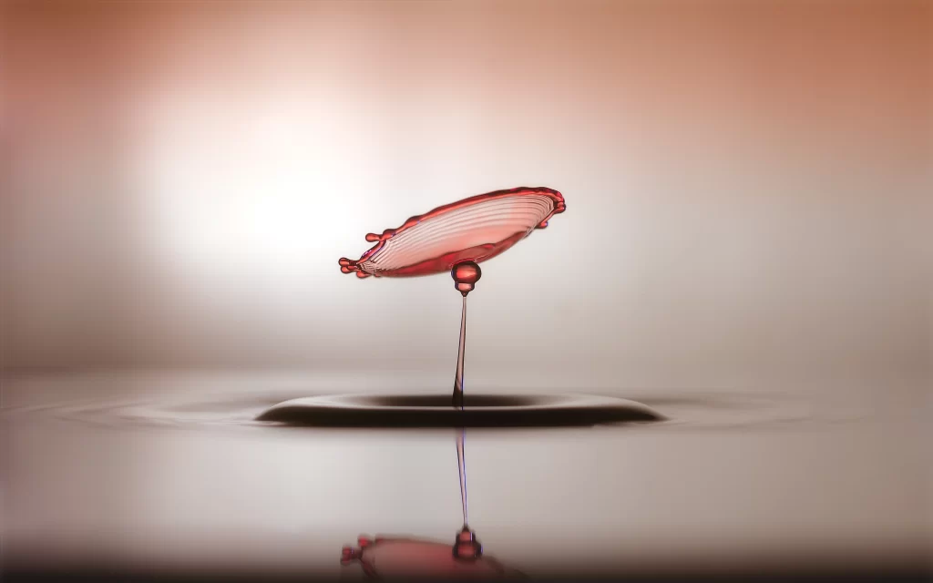 water droplet splash reflection surface red artistic