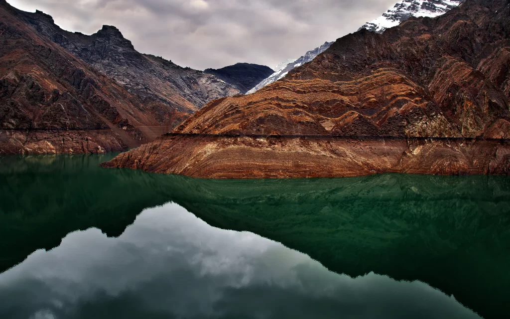 Mountainous Landscape Reflective Water Earthy Tones Cloudy Sky Natural Beauty Tranquil Scene