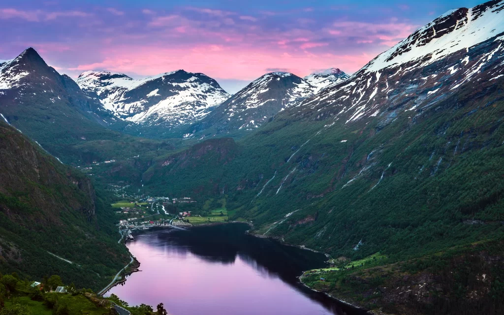 Mountainous Landscape Snow-Capped Peaks Serene Lake Sunset Sky Pink and Blue Hues Lush Greenery