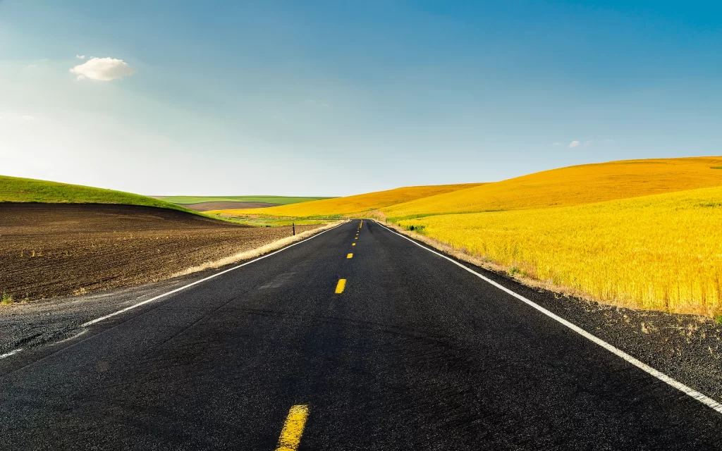Straight Road Rolling Hills Blue Sky Yellow Fields Green Grass