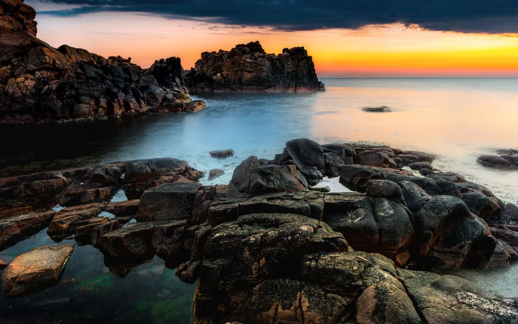 Sunset Rocky Shoreline Ocean Calm Waters Dramatic Sky