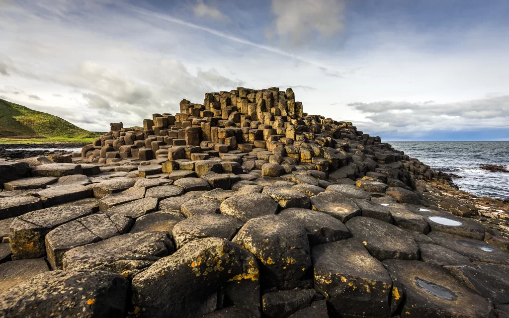 Volcanic Rock Columns Hexagonal Basalt Coastal Landscape Natural Wonder Ocean View Green Hills